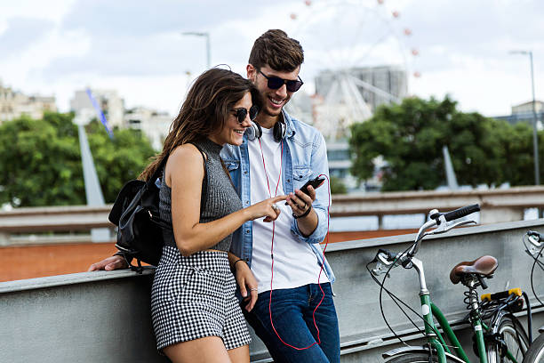 istock Happy young couple using mobile phone in the street. 614985272