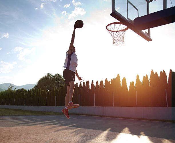 istock Young man jumping and making a fantastic slam dunk 614985370