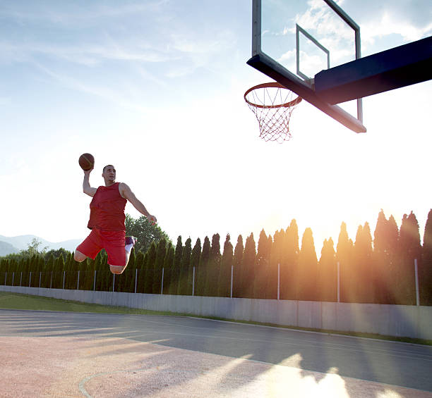 istock Young man jumping and making a fantastic slam dunk 614985582