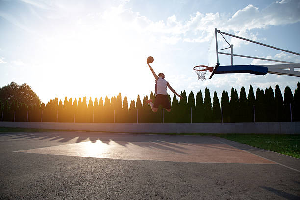 istock Young man jumping and making a fantastic slam dunk 614985714