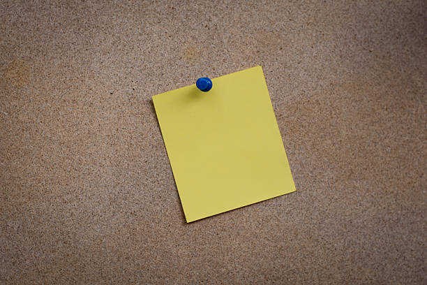 istock Blank yellow paper note pinned on cork board 614985800