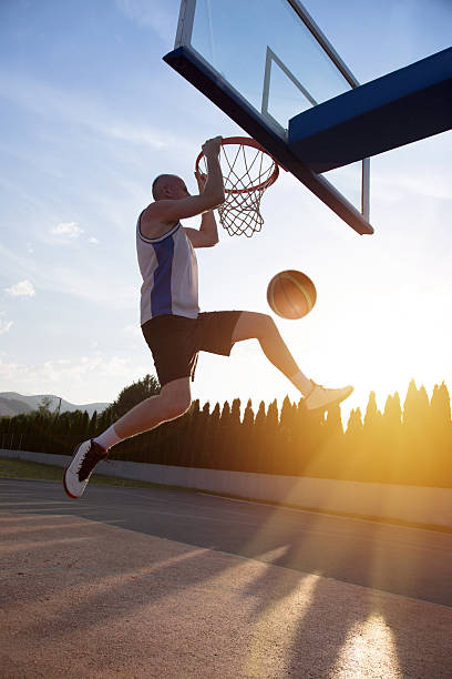 istock Young man jumping and making a fantastic slam dunk 614986218