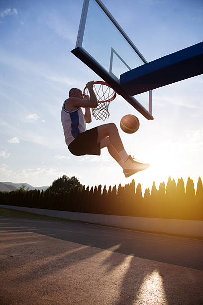 istock Young man jumping and making a fantastic slam dunk 614986270