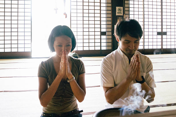 istock Japanese couple praying in a buddhist temple 614986328