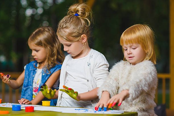istock Children having fun painting with finger paint 614986908