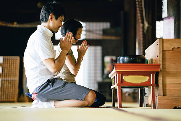 istock Japanese couple praying in a buddhist temple 614987262
