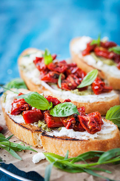 istock Bruschetta with cream cheese, pesto, fresh basil and t 614988378