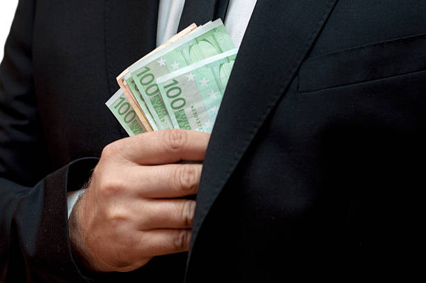 istock Business man putting banknotesin his jacket pocket 614991504