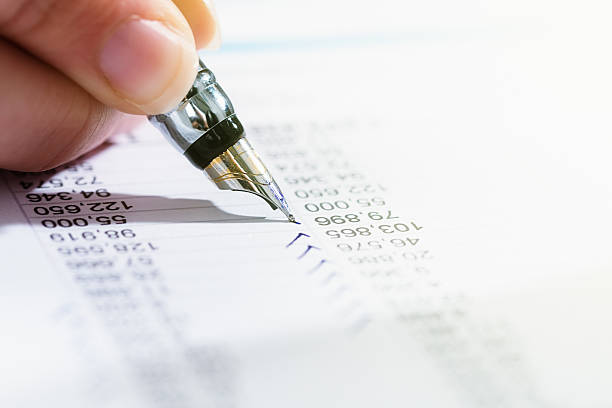 istock Hand checks financial document with fountain pen 614991688