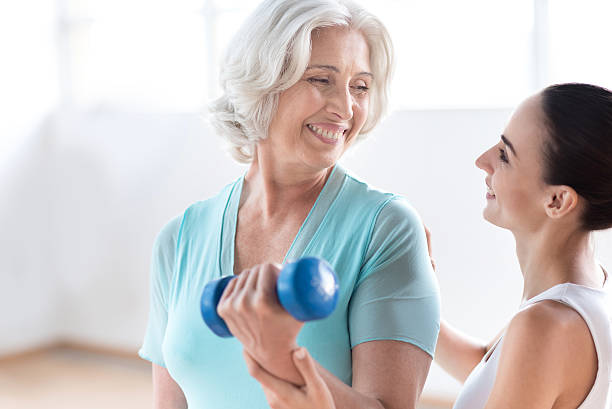 istock Happy pleasant woman holding a blue dumbbell 614991892