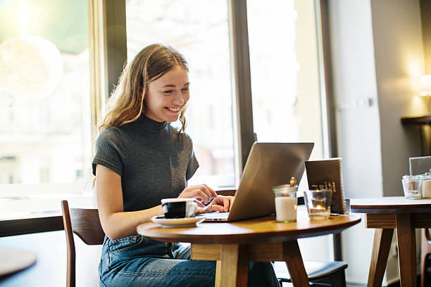 istock Attractive young woman at a cafe using laptop 614991896