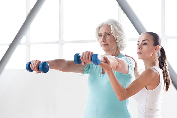 istock Determined persistent woman holding dumbbells in front of her 614991962