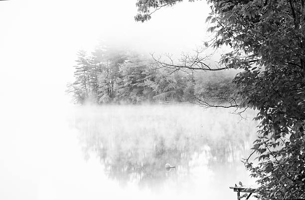 istock Cloud shrouded lake with fall foliage in black and white 614996096