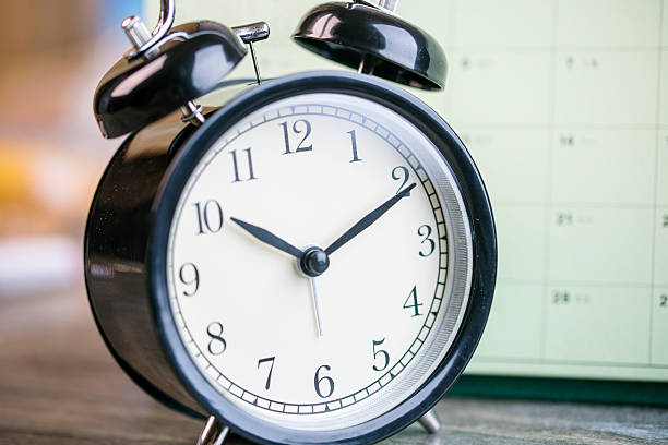 istock alarm clock and calendar on wooden table 614996682