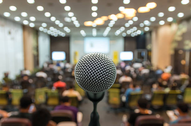 Microphone over the Abstract blurred photo of conference hall or stock photo