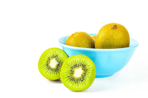 Photo of Kiwi fruit in blue bowl isolated on white background