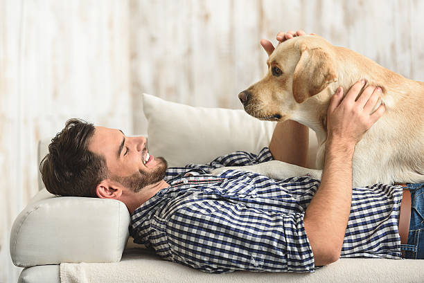 istock man resting with his dog at home 615074660
