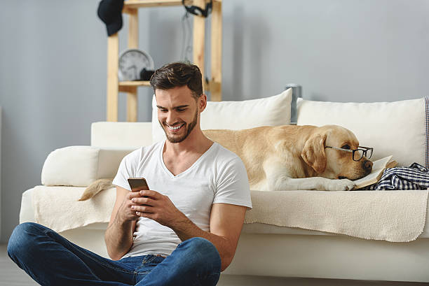istock guy playing on smartphone and does not notice his dog 615075308