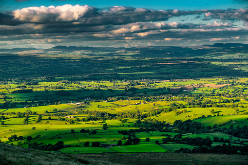 Aerial panoramic view across the green pasture of the Vale of Ewyas, Llanthony Priory and the Gospel Pass overlooked by the Black Mountains in the Brecon Beacons National Park, Wales, UK.