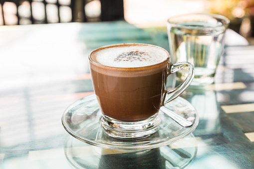 Hot coffee (mocaccino) on glass top table