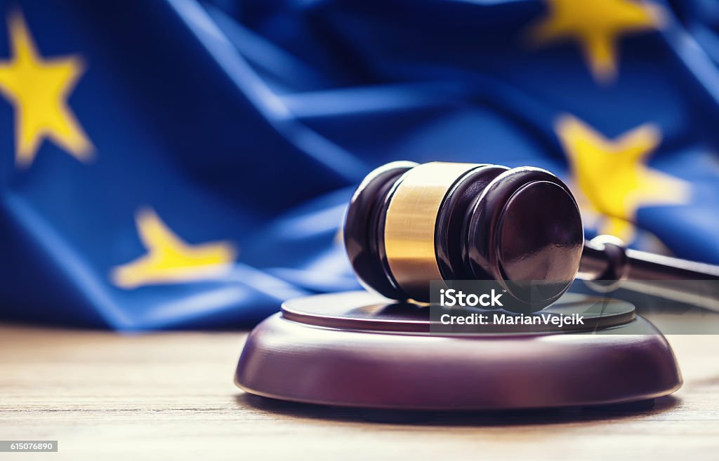 Jueces martillo de madera con bandera de la UE en el fondo. - Foto de stock de Unión Europea libre de derechos