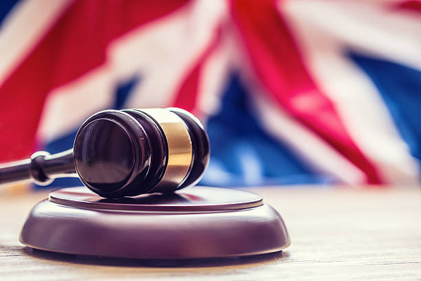 Judges wooden gavel with UK flag in the background. Judges wooden gavel with UK flag in the background. Symbol for jurisdiction. uk stock pictures, royalty-free photos & images