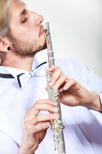 istock Male flutist playing his flute 615077438