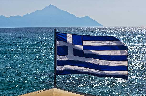 istock Greek flag on sailing ship with mountain Athos in background 615078166