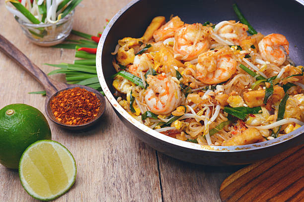 shrimp pad thai Famous traditional thai food shrimp pad thai, rice noodle stir-fry with prawns, tofu and vegetables on cooking pan. thai food stock pictures, royalty-free photos & images