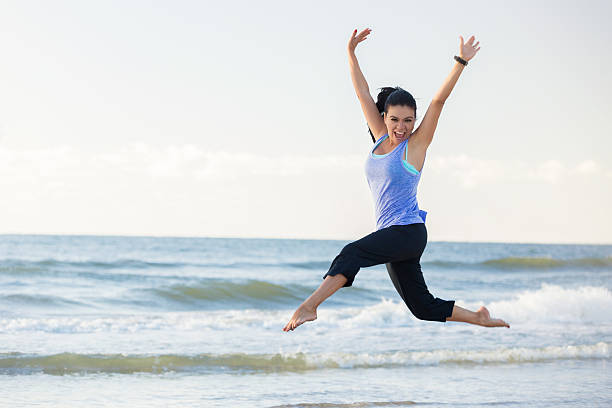istock Joyful woman leaps on the beach 615086644