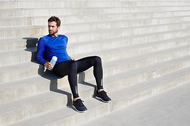 Athlete taking a break Athlete taking a break on steps, looking away sports clothing stock pictures, royalty-free photos & images