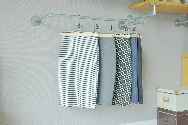 skirts hanging on industrial style clothes rail in walk in closet