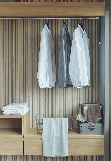 istock Shirts hanging in wooden wardrobe 615088220
