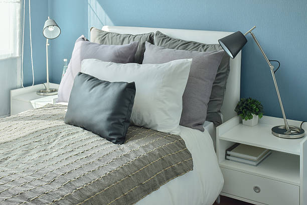 istock Gray, dark gray and beige pillows on bed 615088690