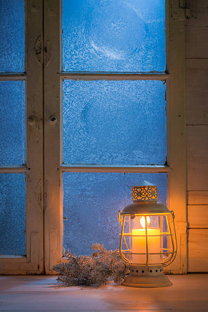 istock Frosted window at night with burning candle for Christmas 615088926