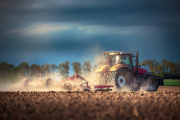 agriculteur dans la préparation de la terre ferme avec tracteur seedbed cultivator - ground preparing photos et images de collection