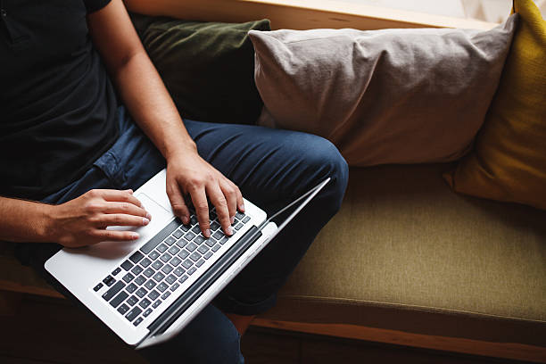 istock Portrait from above man sitting on sofa with laptop 615092470