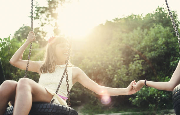 istock Two Friends Swinging in the Park 615092652
