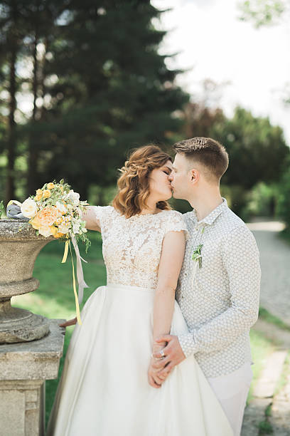 istock Newly married couple running and jumping in park while holding 615094062