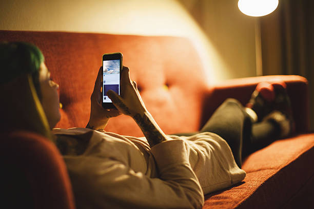 istock Young woman relaxing with smartphone on sofa 615094834