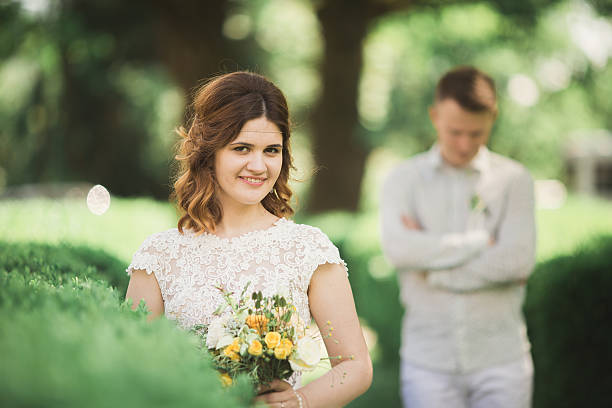 istock Bride posing and smiles while groom waits on the background 615095044