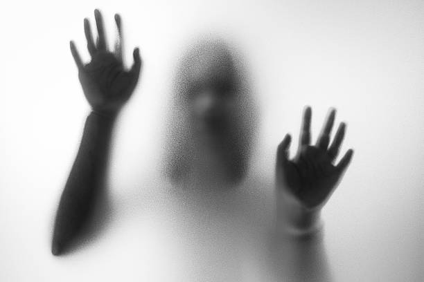 Horror woman behind the matte glass Horror woman behind the matte glass in black and white. Blurry hand and body figure abstraction.Halloween background film noir style photos stock pictures, royalty-free photos & images