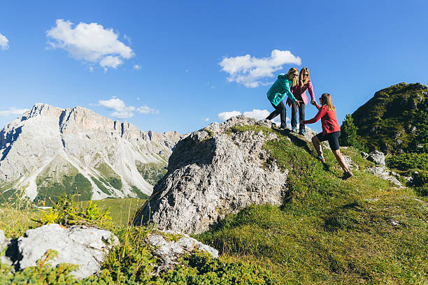 istock Adventures on the mountain: women  helping each other 615097654