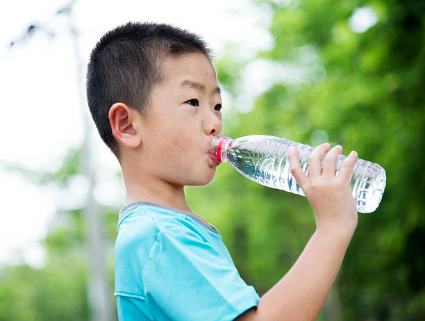istock Little asian boy drinking water outdoors 615097972