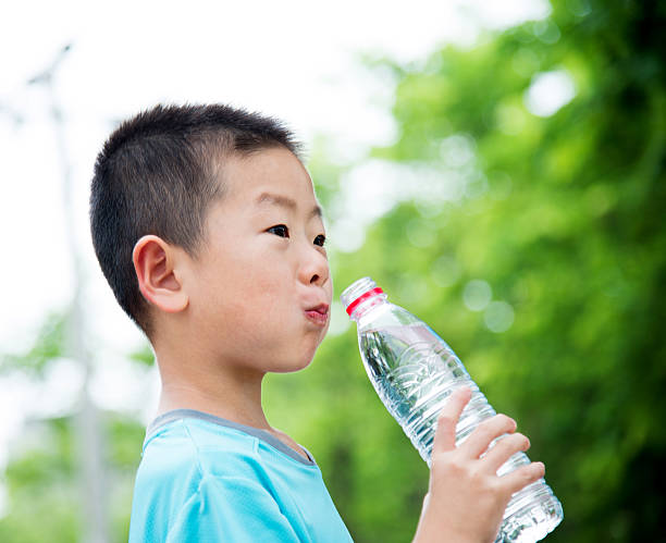 istock Little asian boy drinking water outdoors 615098478