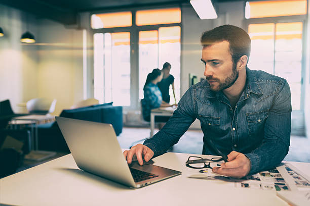 istock Man in modern office start-up working on laptop. 615099564