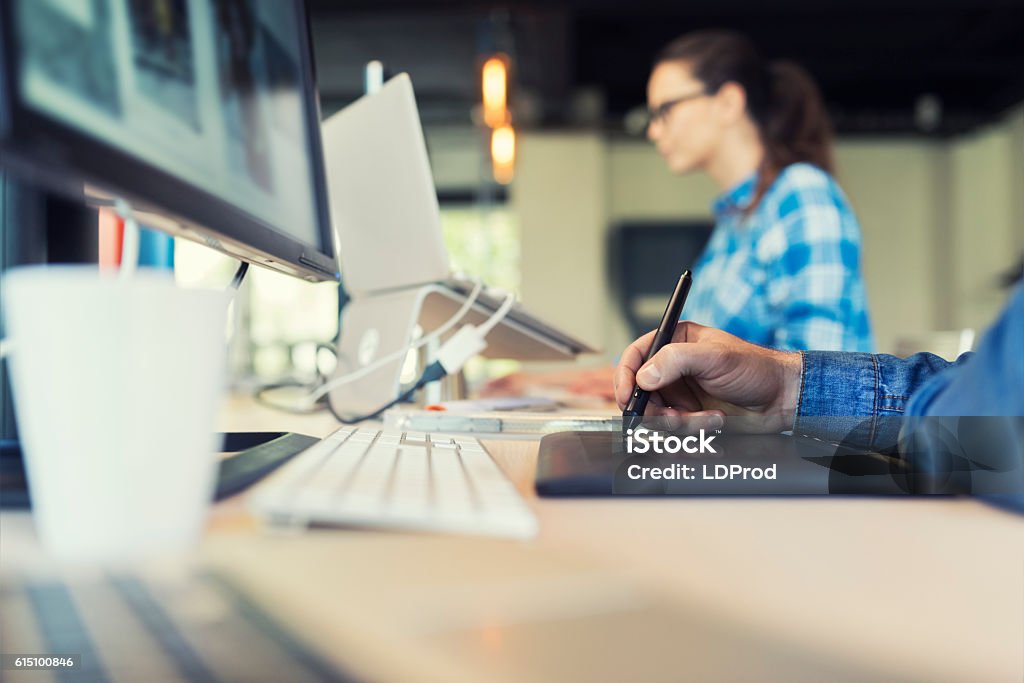 Man Working on graphic tablet in modern startup Close-up on hands male designer. Working on graphic tablet in modern space office. Young female artist background Real Estate Office Stock Photo