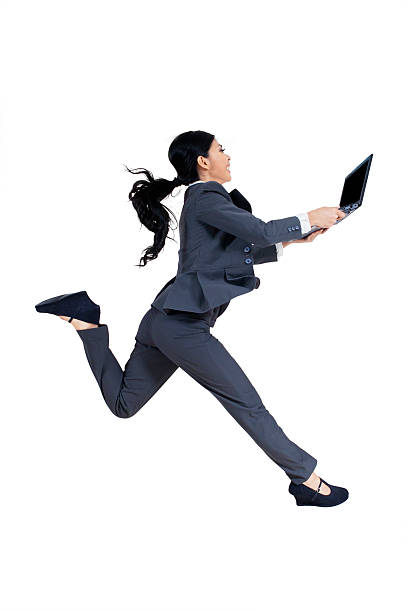 businesswoman holds laptop and runs in studio - japanese ethnicity women asian and indian ethnicities smiling imagens e fotografias de stock