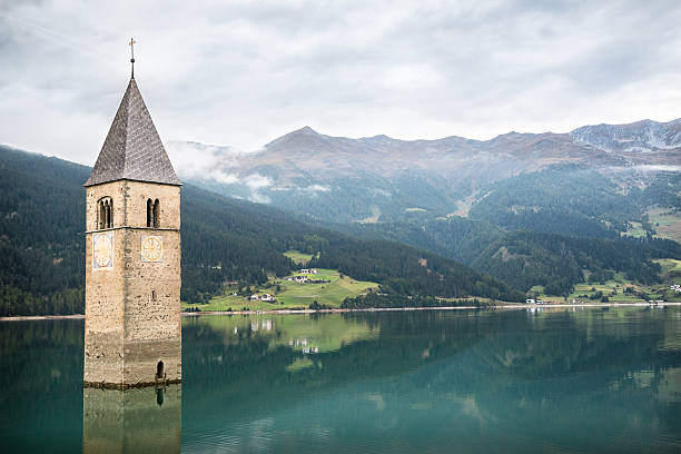 torre da igreja do lago di resia em curon venosta - lake mountain north tirol austria - fotografias e filmes do acervo