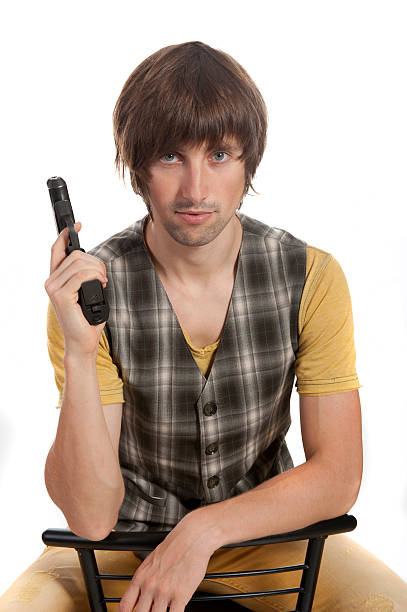 istock young man with a gun in his hand 615102716